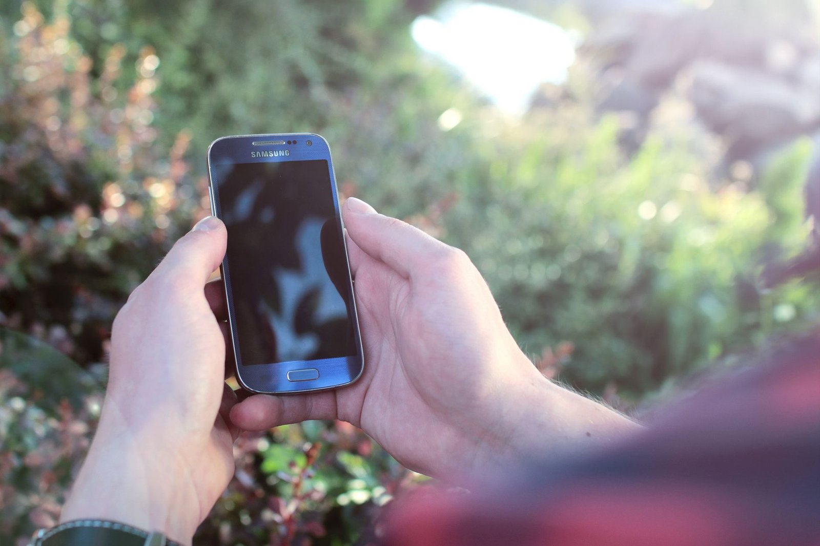Hands holding a smartphone to install the app