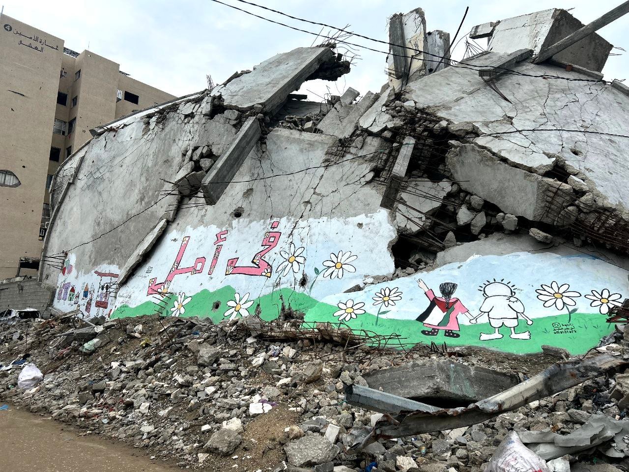 Wandbild mit Kindern und Blumen an einem zerbombten Gebäude in der Al-Thawra-Straße, Gaza — Foto: Hla.bashbash, Wikimedia, CC BY 4.0